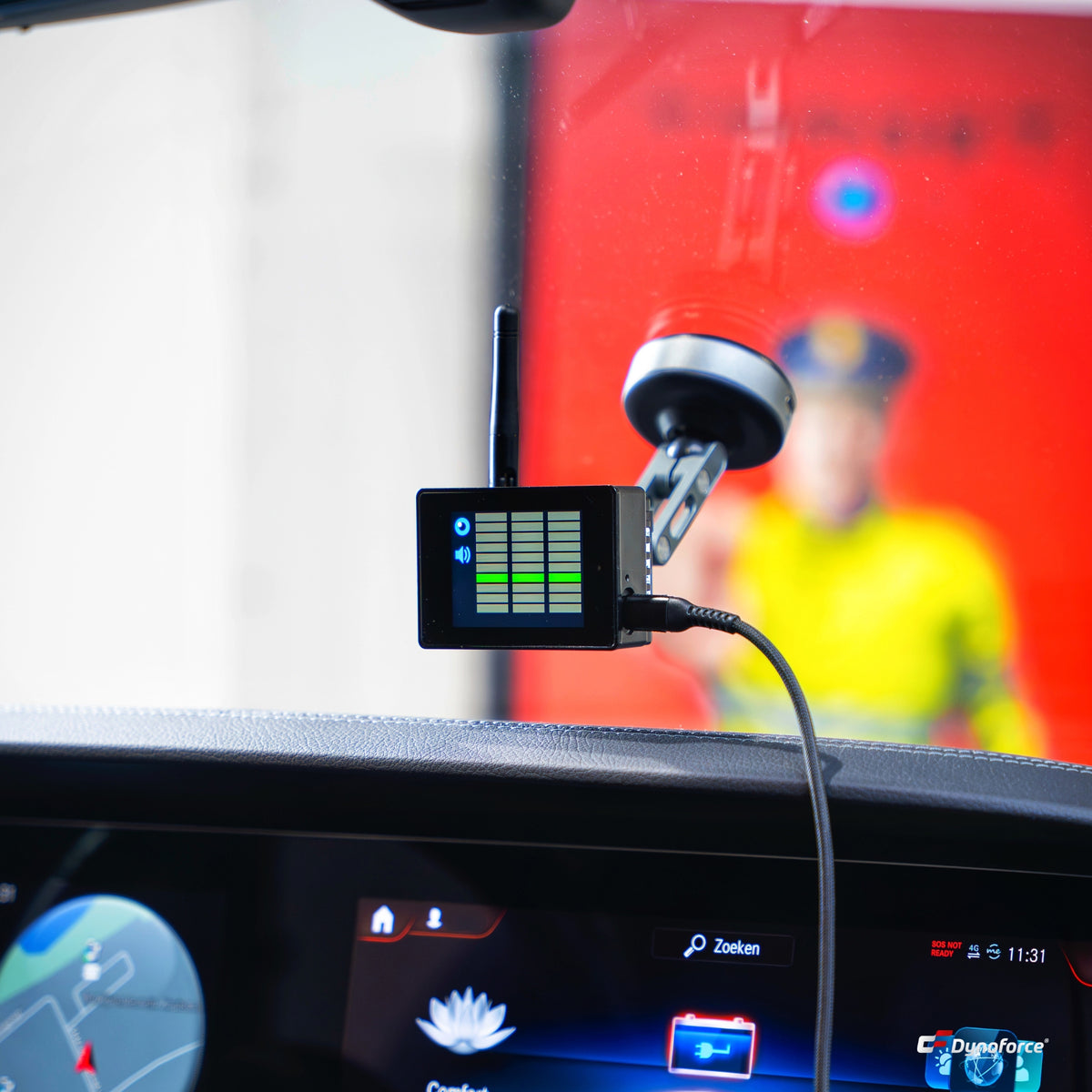 Target Blu Eye GO above the dashboard, with an emergency worker in a yellow jacket out of focus in the background
